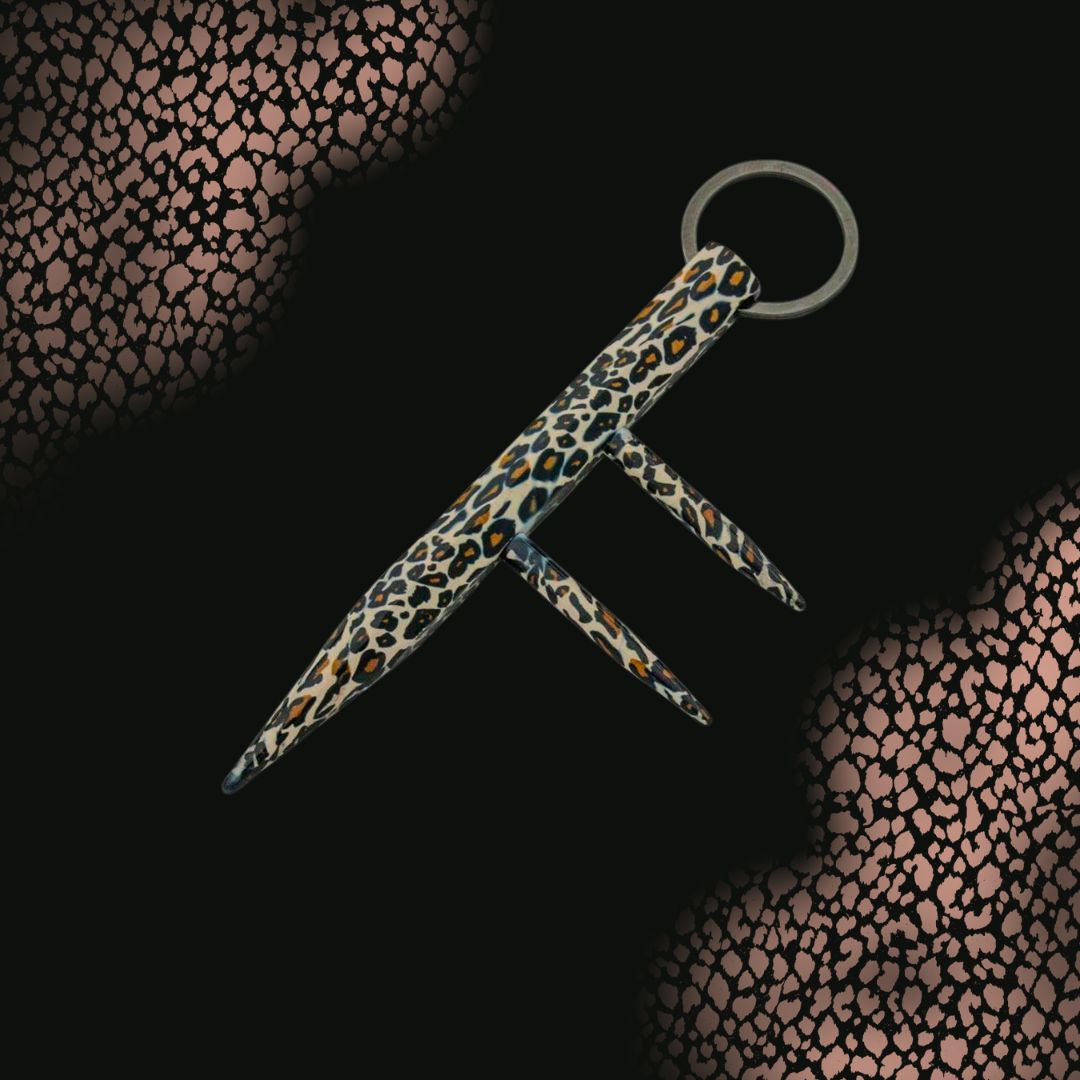 three prong leopard print kubaton keyring on black spotted background