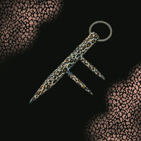 three prong leopard print kubaton keyring on black spotted background