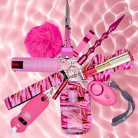 Collection of pink self-defense keychain tools and accessories on a pink watercolor background