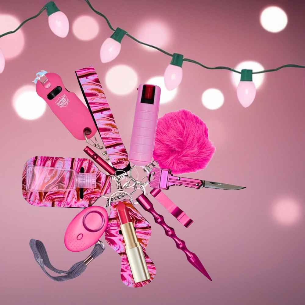 Pink marbled self-defense keychain with various tools on a pink background with string lights